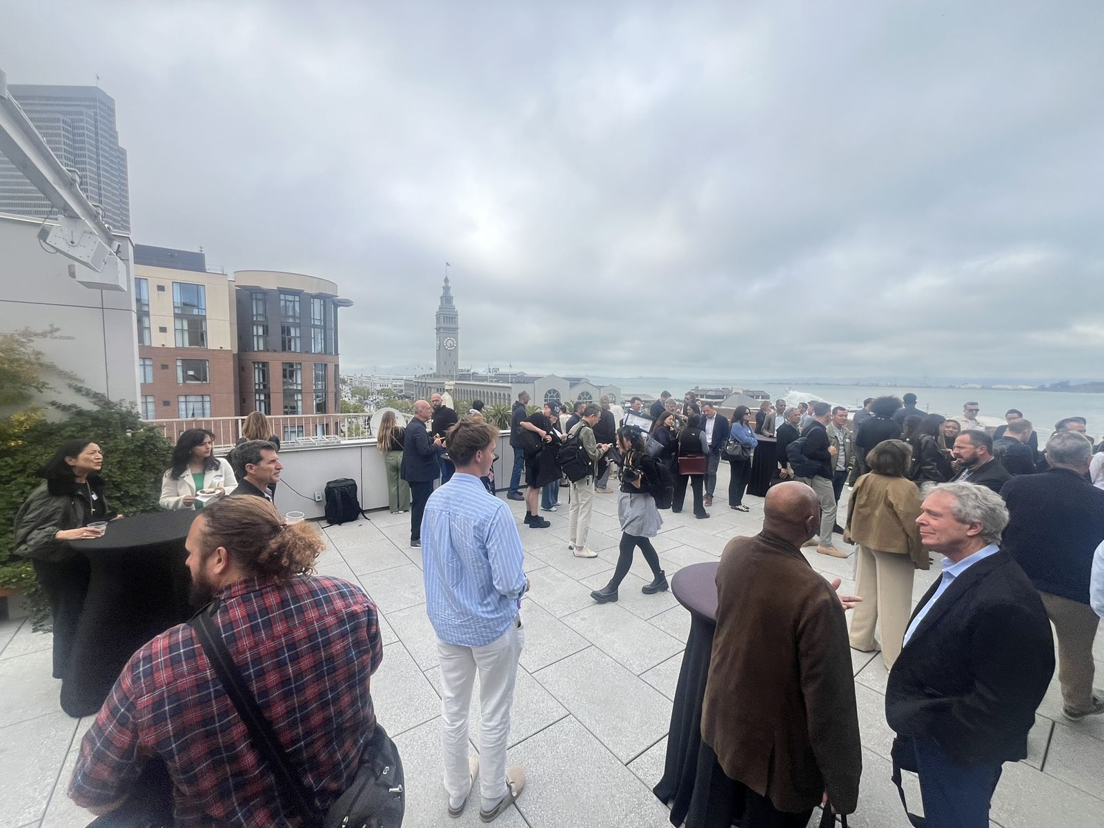 Rooftop reception, attendees with San Francisco Bay and the Ferry Building behind