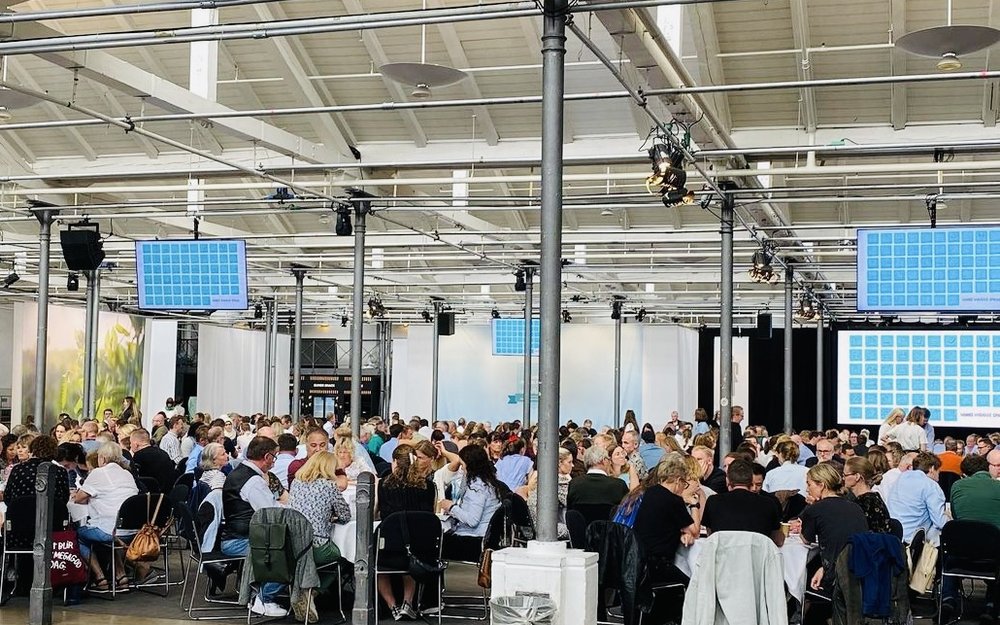 A large hall of people working in groups