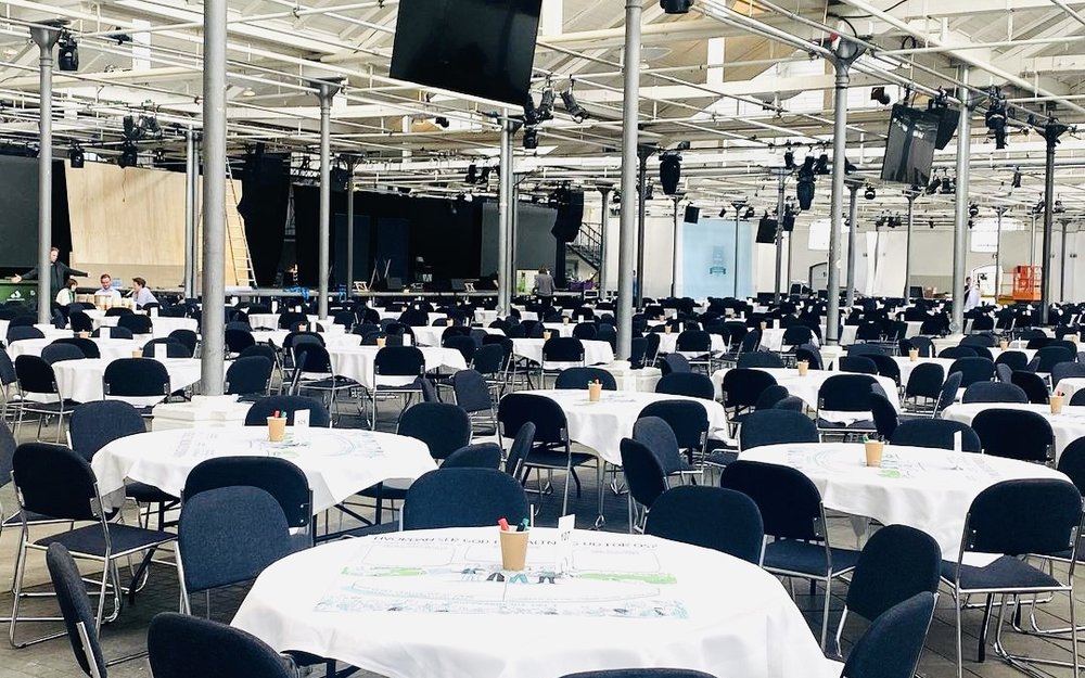 A venue set up with round tables before a session